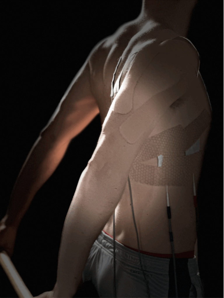 Athlete receiving NEUBIE therapy with muscle tape applied during recovery treatment at Electric Rehab and Fitness in Missoula, Montana.