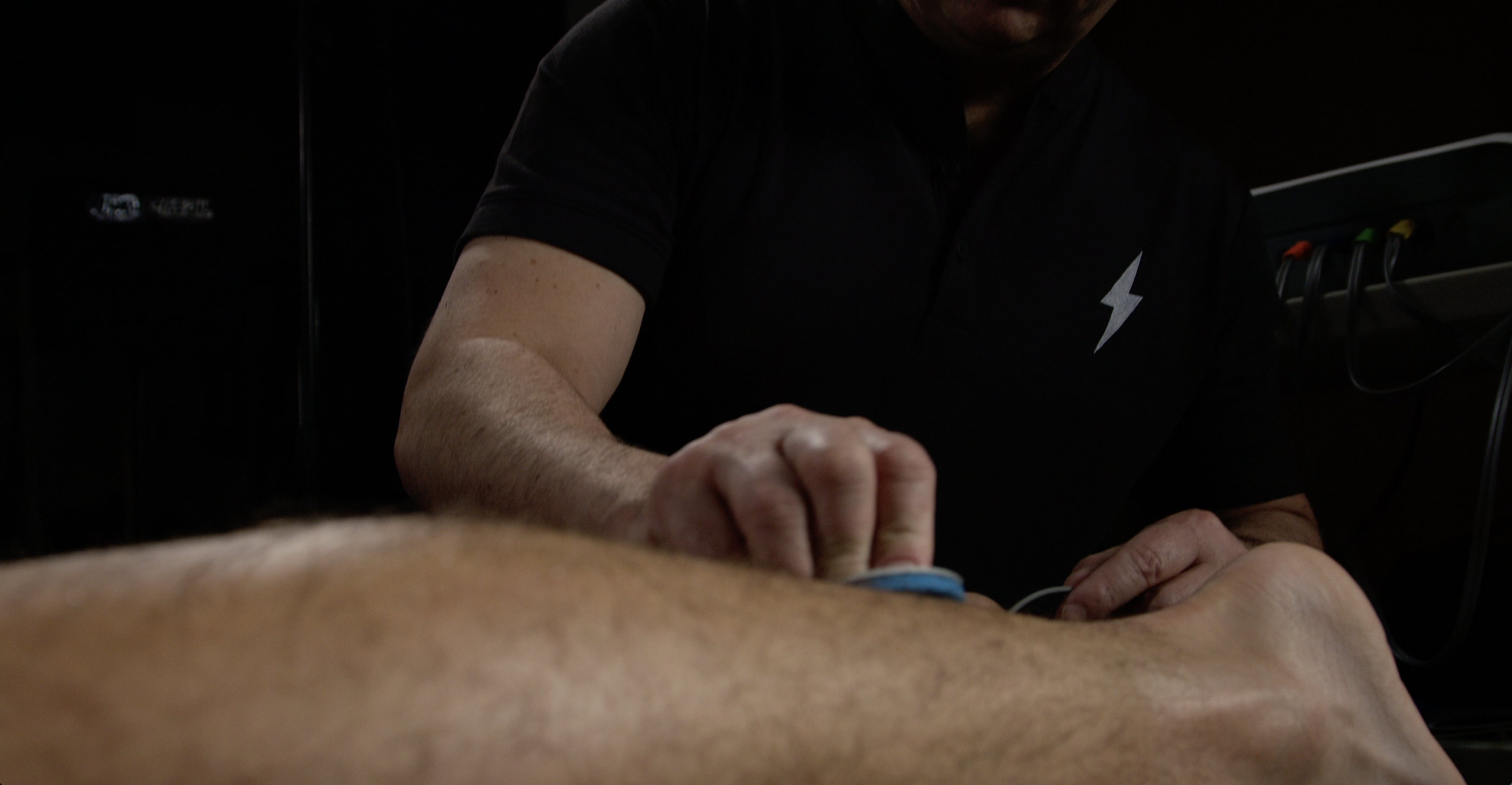 Practitioner performing NEUBIE mapping therapy on athlete’s leg at Electric Rehab and Fitness in Missoula Montana