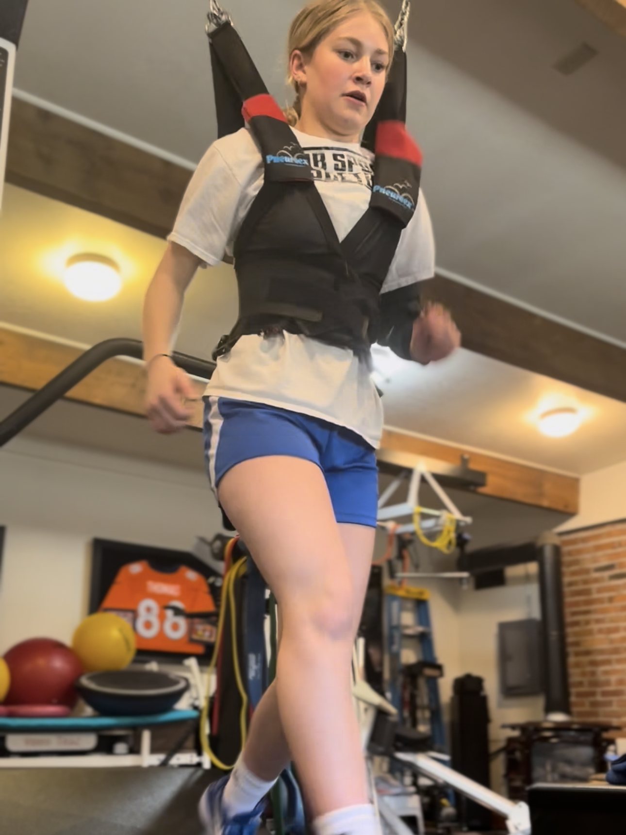 Athlete training in a weighted vest on the high-speed treadmill during a speed and agility session in Missoula