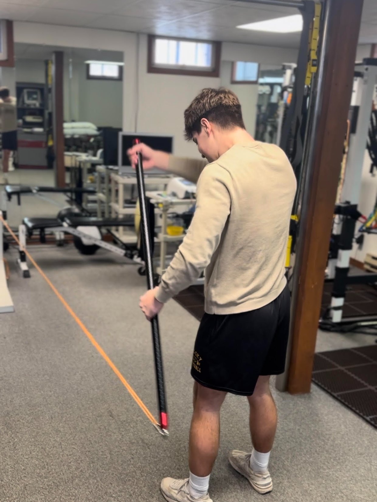 Athlete working a resisted row with a bar and band during sports performance training in Missoula