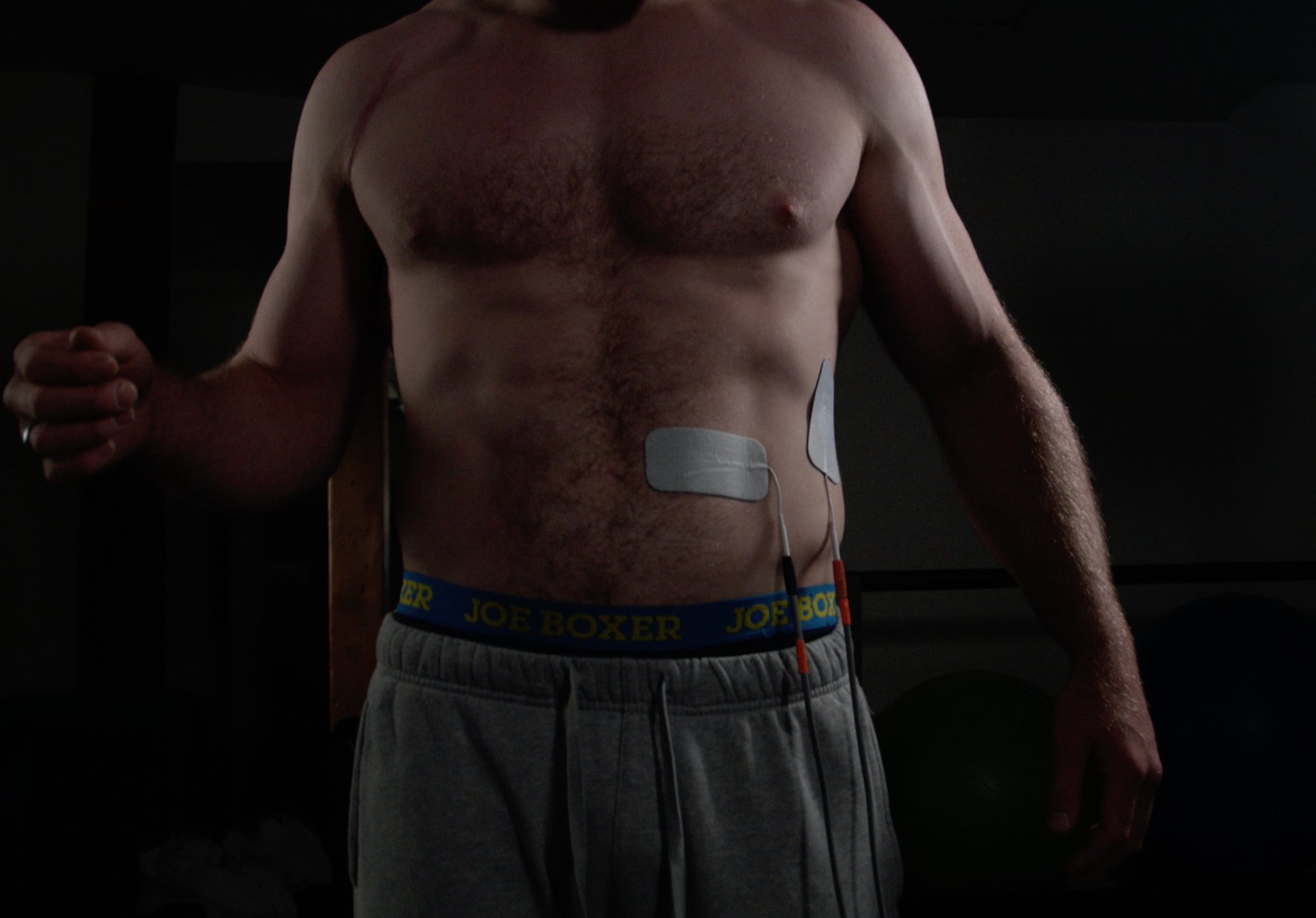 Patient with Neubie electrodes on the left side of his abdomen during a session in Missoula